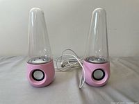 Front view of both pink water speakers with clear cone tops and visible front speaker drivers