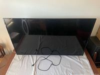 Front view of 50-inch TCL TV on stand with power cord visible