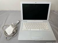 MacBook open with power adapter beside