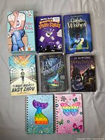 Front view of all eight books and two notebooks