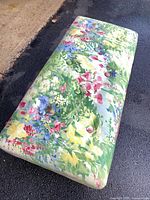 Top view showing full floral upholstered surface and tufted buttons