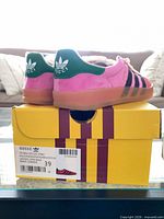 Rear and side view of sneakers on original box shows branding size label EU 39