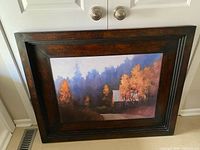 Full view of framed landscape print leaning against door