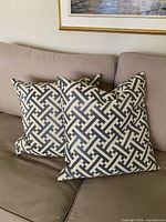 Front view of both square pillows showing full geometric pattern and color