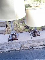 Two lamps showing shades, chrome columns, wood bases