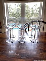 Front view of all six clear balloon burgundy wine glasses