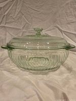 Side view of green glass casserole with lid showing ribbed pattern and handles