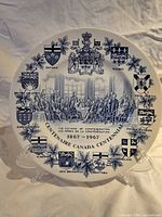 Front view of blue-white commemorative plate with crests and central scene