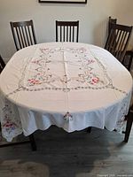 Full view of tablecloth on dining table showing embroidery layout and size