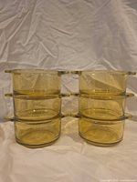 Front view of two stacks of three amber glass bowls showing color, handles and stackability