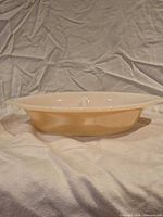 Side profile showing peach lustre exterior and handle