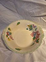 Top view showing entire bowl, floral interior pattern, scalloped rim and handles