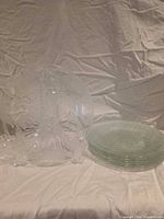 stack of six clear glass plates and one on stand