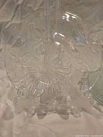 Front view of one Hibiscus plate on stand showing raised floral pattern