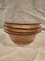 Stack of four pink frosted grape pattern glass bowls