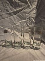 front view of four Luminarc shot glasses with labels visible on two