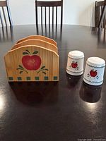 Front view of wooden napkin holder and both shakers