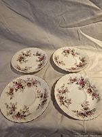 Top view of four Royal Albert Lavender Rose saucers showing pattern and gilt edges