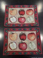 Front view of both placemats showing apple design and red border