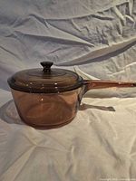 Side view of amber glass saucepan with Pyrex lid