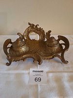 Front view of brass double inkwell stand, lids closed