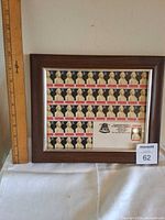 Framed stamp display next to ruler for scale