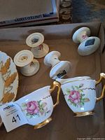 Teacup, creamer and four candlestick holders with rose and gold pattern