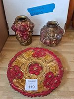 Group shot of plate and two vases showing front designs