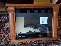 Front view showing wooden mantel, glass panel, controls, Heat Surge logo