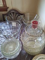 Assorted glass bowls and hurricane candle holder on table