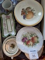 Group shot of assorted china including mug, teacup, saucer, plates and relish dish