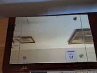 Top view of mirrored tray showing reflective surface and metal corner mounts