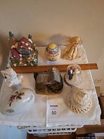 Tabletop view of all items including Easter egg, cottages, rabbit, trinket box, bell, cake topper, doll
