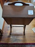 Closed wooden sewing stand on legs