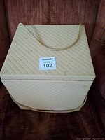 Exterior of cream quilted sewing box with rope handle