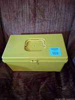 Closed yellow sewing box with handle and latch
