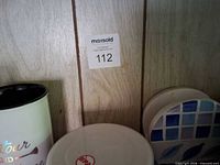 Shelf showing mugs, tooth brush holder, coasters