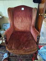 Front view of burgundy upholstered wingback chair
