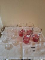 Group of 4 wine glasses and 4 floral tumblers on cloth
