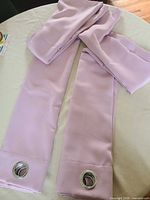 Two folded lavender blackout curtain panels laid out showing grommet headers