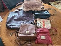 six purses arranged on table showing overall variety