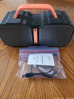 Front view of Bugani speaker showing dual grilles and orange handle