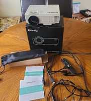 Projector on box with accessories laid out