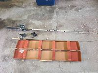 Open Woodstream case with three rods and reels laid beside it