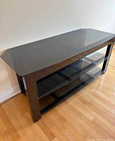 front view of TV stand showing glass top and shelves