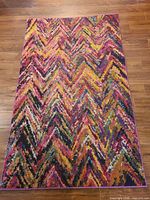 Full view of multicolour chevron rug on wood floor