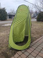 Front view of fully opened green pop-up privacy tent