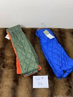 Both scarves laid flat showing outer quilted nylon and fleece linings
