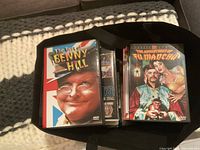 Bag containing The Best of Benny Hill and The Adventures of Fu Manchu DVDs