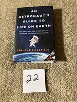 Front cover of signed hardcover book with lot number card